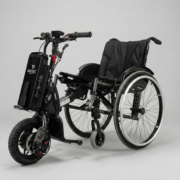 Mobilitätslösung: Schwarzer Ottobock Motus CV 2 Rollstuhl kombiniert mit einem kompakten Batec Mini 2 Elektro-Zuggerät